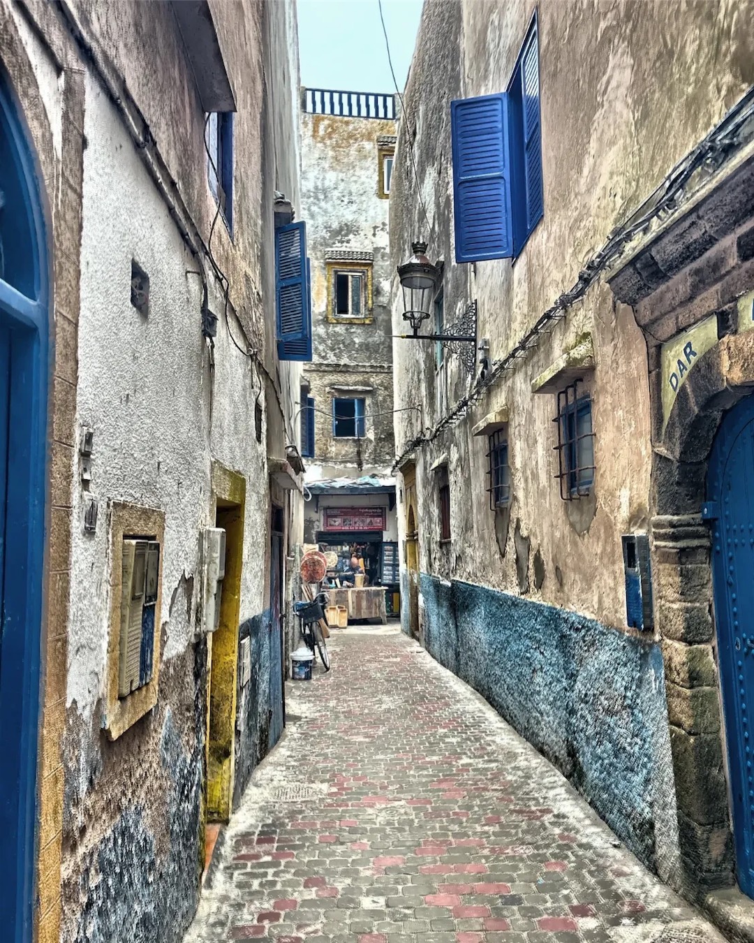 A medina alley in Essaouira with blue shutters